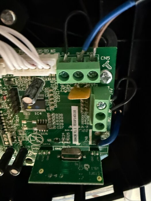 Elektronisk krets med ansluten kabel markerad som GND och DOOR i en kopplingsplint på en kretskort.
