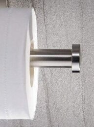 Toalettpappersrulle som verkar sväva fritt på en metallhållare, vilket ger en illusion av viktlöshet.