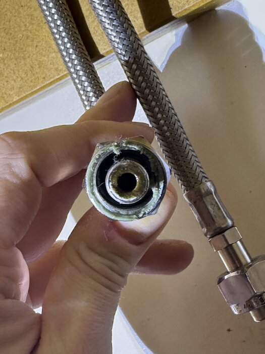 Närbild av en vattenanslutning med en rak koppling på soft-pex, visande grönt vaxliknande tätning på en lekande mutter.