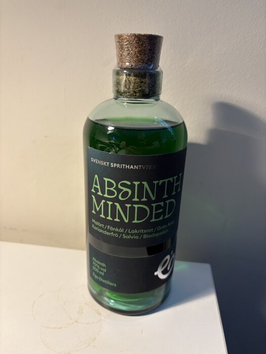 Flaska med grön sprit, etiketten säger "Absinth Minded" och visar ingredienser som malört och fänkål.