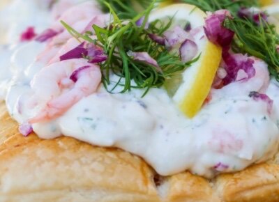 Skagentårta med räkor, dill, rödlök och citronskiva på ett krispigt bröd, garnerad för nyårsafton.