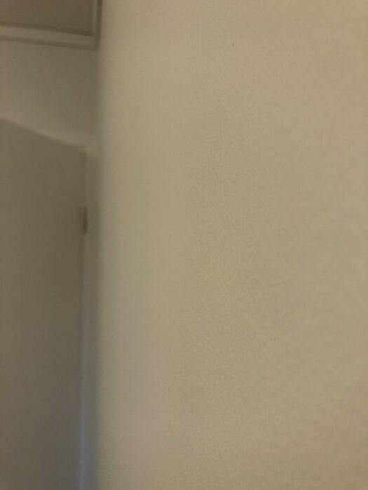 Vägg målad och spacklad, visar slutresultat med fokus på ytskiktets jämnhet på tretex.