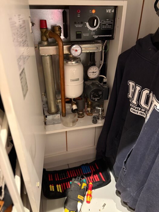 Elpanna i litet skåp med verktyg på golvet, förberett för reparation av kontaktor.