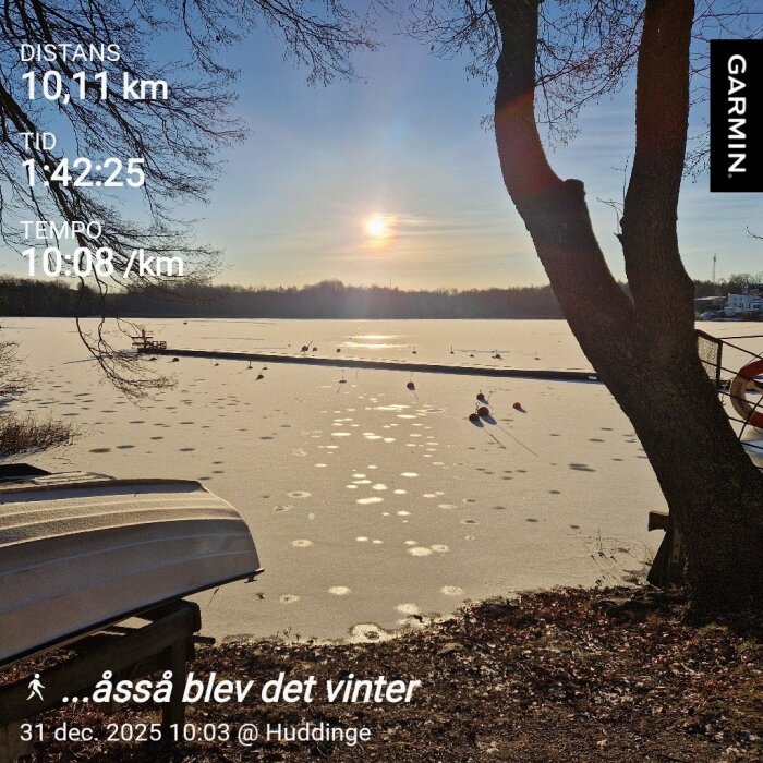 Frusen sjö i vintersol med båtar och fåglar, träd i förgrunden, uppgifter om distans, tid och tempo från löprunda vid Huddinge, datum 31 dec 2025.