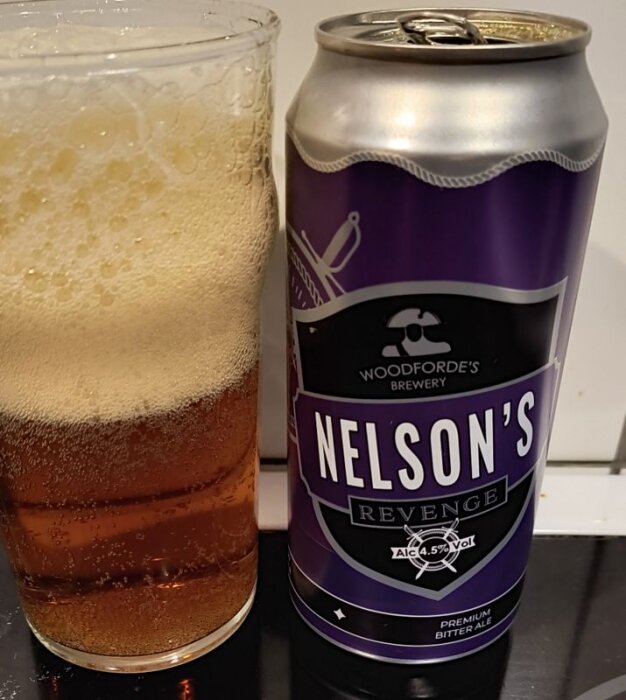 En burk och ett glas fyllt med ale, märkt "Nelson's Revenge" från Woodforde's Brewery.