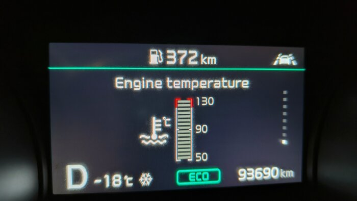 Instrumentpanel med motor temperaturindikator vid -18°C, distans 93690 km, och bränsleräckvidd 372 km. Kupevärmare diskuteras.