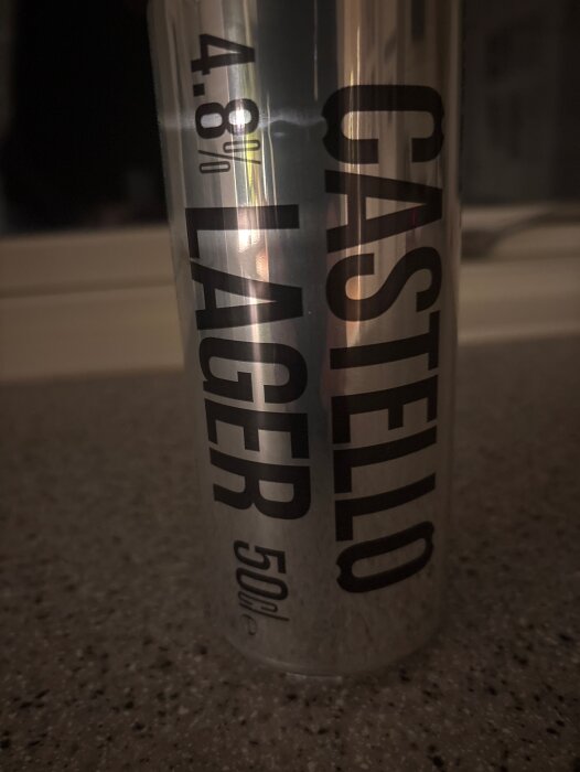 Burk öl av märket Castello Lager, alkoholhalt 4,8%, står på en köksbänk.