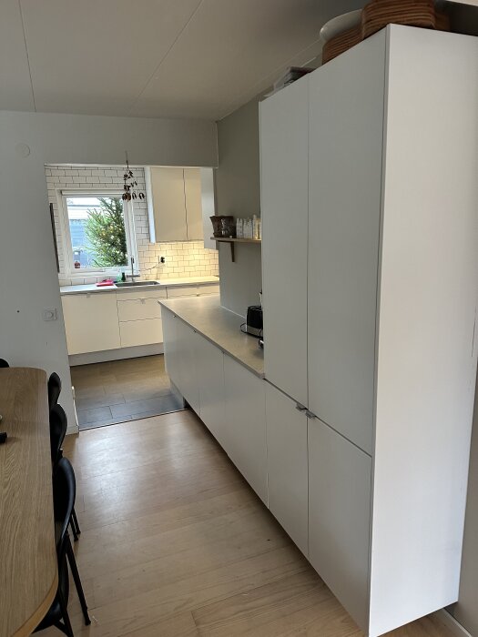 Kök från 2015 av Marbodal med vitvaror, ljusa skåp och träbord.