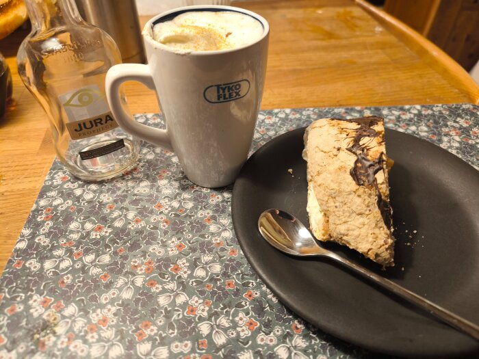 Budapeststubbe på en svart tallrik bredvid en kopp Irish coffee och en tom flaska whisky på ett blommigt underlägg.