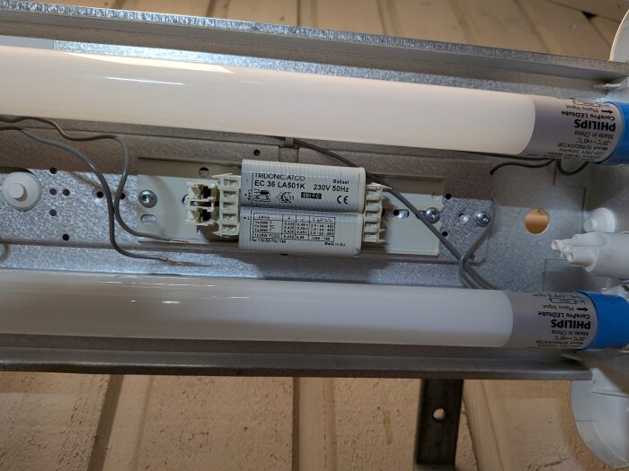 LED-lysrörsarmatur med Philips CorePro LED T8-rör och ballast i en takinstallation, med kopplingsdetaljer synliga.