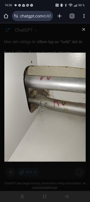 Rör under diskbänk med isolerande material och märkning, inom äldre bostad från 70-talet.