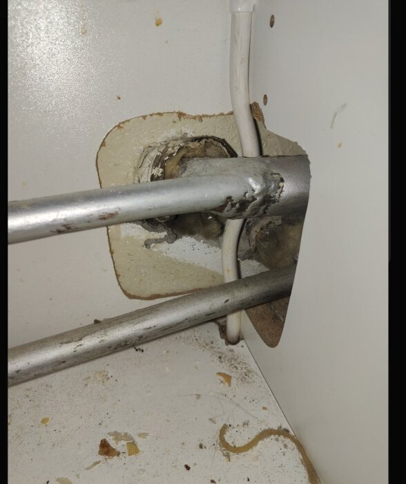 Rörgenomföring med isolering i vägg, visar tydlig tätning kring rören.