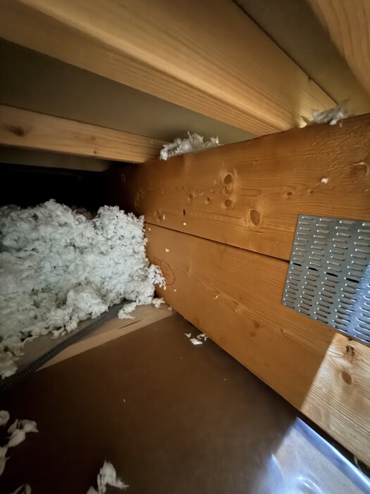 En bild av en träkonstruktion med isoleringsmaterial ovanpå.