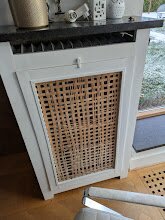 Vitt element med rutigt elementskydd i en tegelbyggnad.