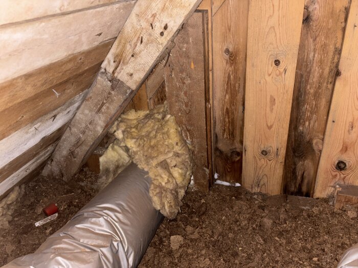 Vind med träväggar, exponerad isolering och ventilationsrör synliga.