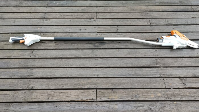 Förlängare och såg, modell Stihl GTA26, placerad på altandäck med spikrader synliga.
