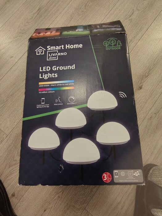 Förpackning med Smart Home Livarno Home Zigbee 3.0 LED-utebelysning, halvsfäriska lampor för marken, 16 miljoner färger och justerbar färgtemperatur.