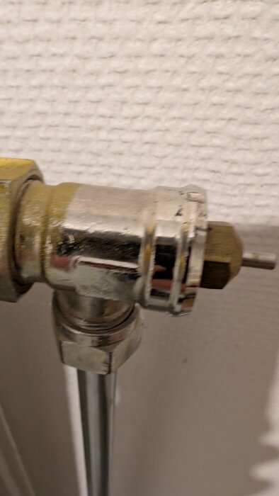 Radiatorventil från 1978 med 26 mm diameter, på en vit vägg.