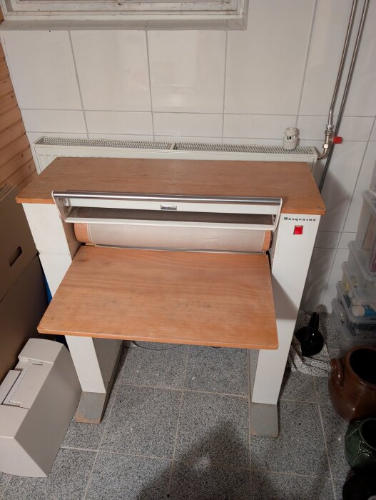 Kallmangel från Husqvarna Vapenfabriks AB, frihängande modell med träram och rullfunktion, fotograferad i en kaklad tvättstuga.