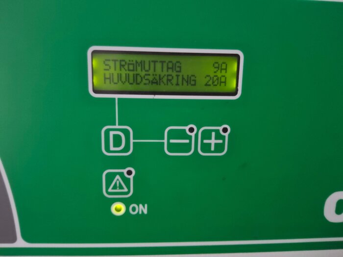 Display på ett elektriskt panel visar "strömuttag 9A, huvudsäkring 20A" med en varningsikon och lysande ON-lampa.