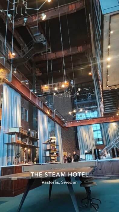 Inside The Steam Hotel in Västerås with industrial design, large windows, and lighting fixtures.