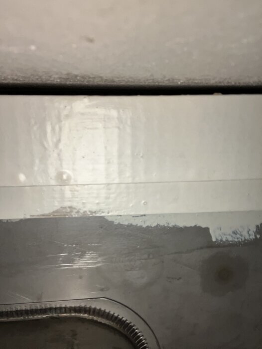 Inuti köksskåp visar ovansidan av diskbänken och skåpets inre, med fokus på strukturer och ytor från ett kök från 40-talet.