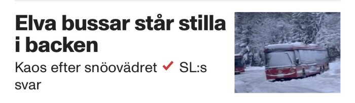 Buss står stilla i snöig backe omgiven av snötäckta träd, efter snöoväder som orsakat trafikstopp.