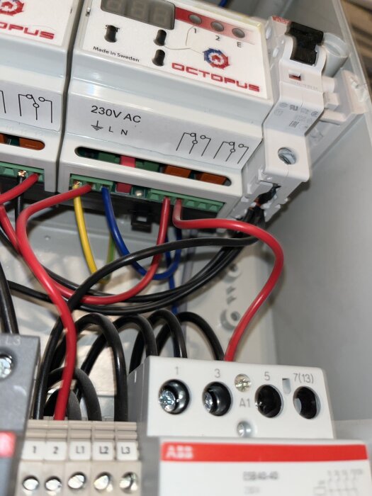 Elektrisk kopplingsbox med märkt 230V AC, visa röda och svarta kablar anslutna till kontaktorer och brytare, märkt "Octopus".