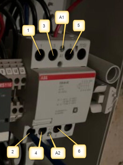 Relä kapslat i en elektrisk låda med märkningar 1, 2, 3, 4, 5, 6 och A1, A2. Märke ABB synligt på reläet.