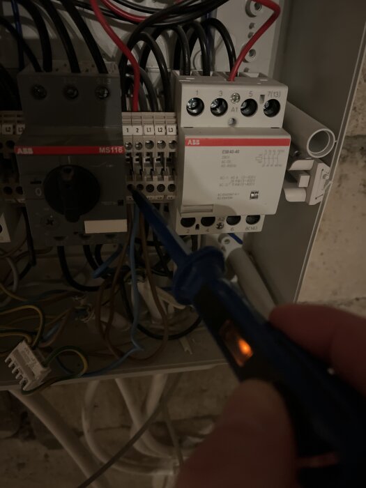 Ledningskontroll med spänningsprovare i elskåp.
