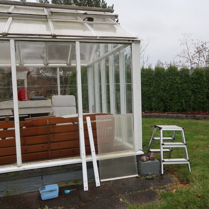 Växthus med 4 mm glassidor, två glasrutor fogade kant i kant med silikon syns, stege och verktyg bredvid.