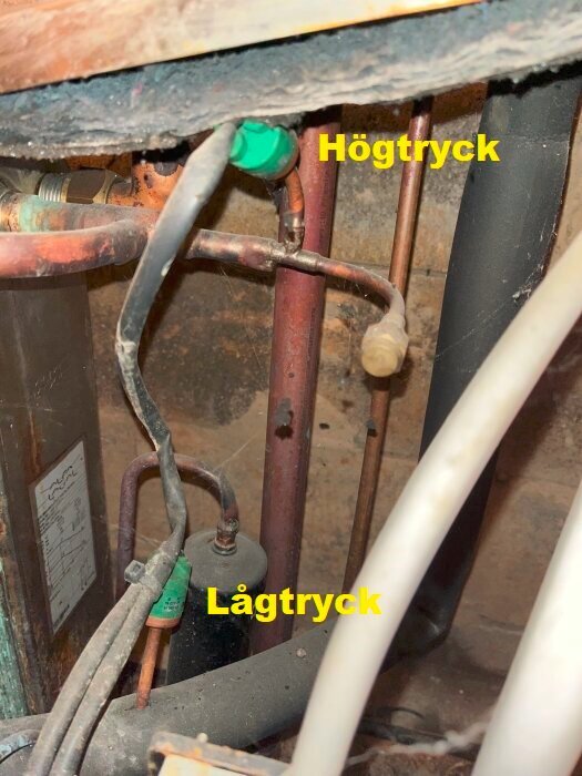 Rör och ledningar märkta med "Högtryck" och "Lågtryck" i ett mekaniskt system, inklusive rör och klämmor.