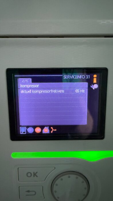 Display på en elektronisk enhet visar "kompressor" med aktuell frekvens 65 Hz, omringat av flera kontrollknappar och ett grönt ljus.