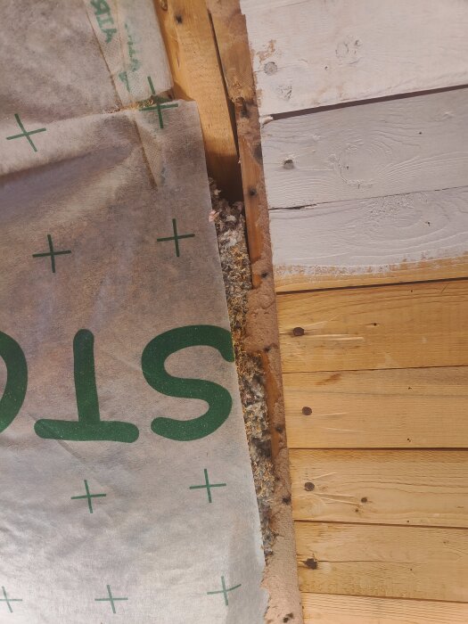 Ångbroms installerad över takstolar med synlig cellulosa isolering och träpanel; anslutningen mellan ångbroms och tak beskrivs som otät i renoveringsprojekt.