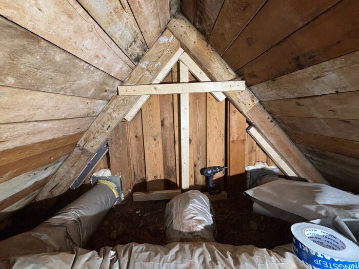 Takvinkel med träreglar monterade, borrmaskin synlig. Reglarna används för att fästa duk utan att påverka fasadplankorna.
