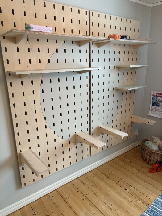 Verkstadsinspirerad pegboard med björkplywood och målad MDF, utrustad med hyllor, i ett uppdaterat pojkrum.