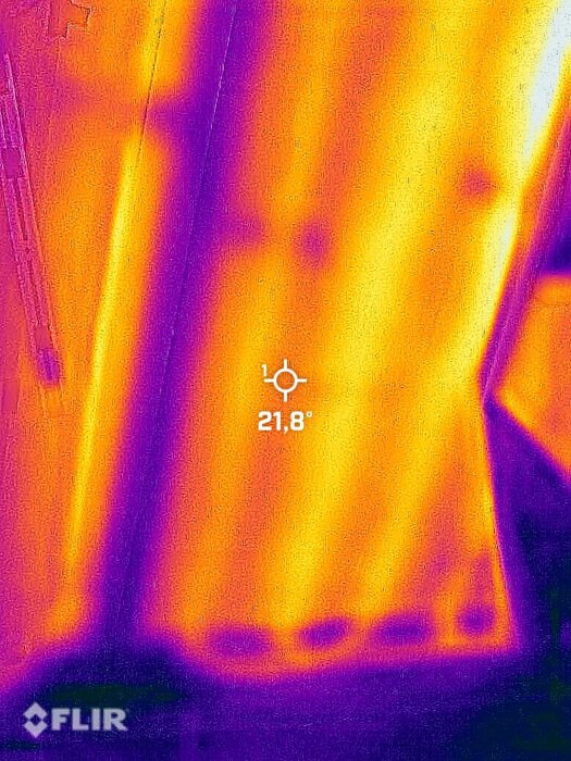 Värmekamera som visar värmemönster av golvslangar i ett rum, med en temperatur på 21,8 grader Celsius.