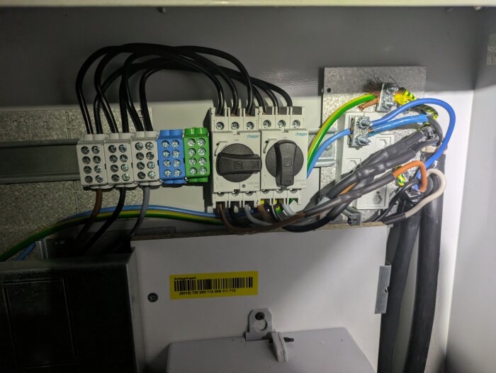 Elektriska kopplingsplintar med kablar och strömbrytare i ett elskåp. Jordledare och kabeldragning synliga för elinstallation illustration.