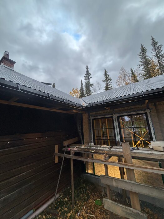 Gamla taket rivs, byggställning uppställd vid huset under molnig himmel. Nya isoleringen ska bli 340mm istället för tidigare 120mm.