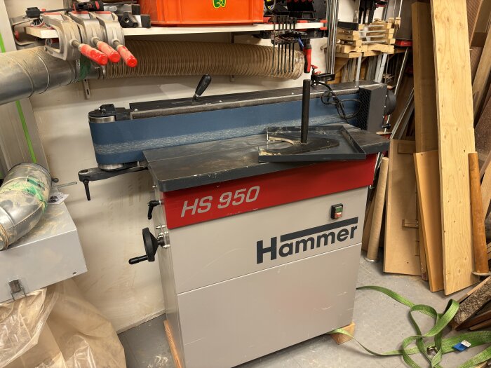 Slipmaskin Hammer HS 950 i en verkstad, omgiven av träplankor, verktyg och slangar.