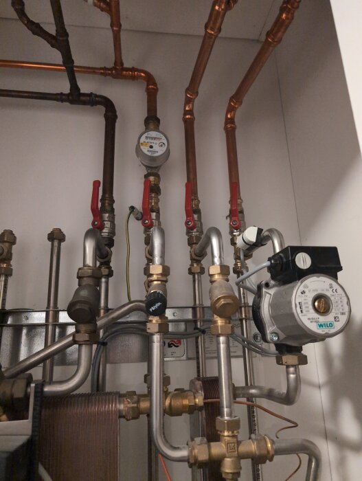 Värmerör, ventiler och en Wilo-pump installerade i ett värmesystem.