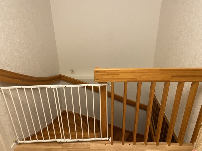 Trappa med träbalustrad och barnsäkerhetsgrind i ett hus från 1850-talet, del av diskussion kring ombyggnad och planlösning.