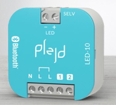Blå Bluetooth LED-dimmer från Plejd med anslutningar och etiketter för N, L, och SELV.