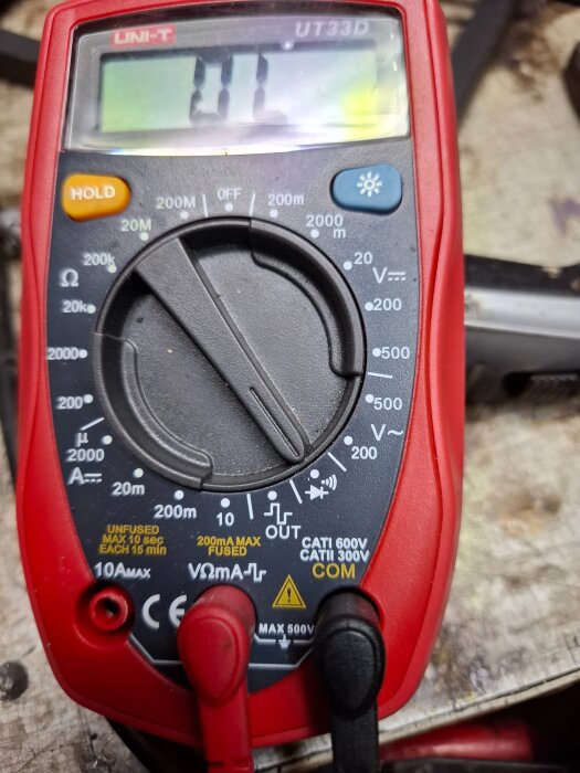Digital multimeter med rött hölje inställd på diodmätningsläge. Visar värdet "OL" på displayen.