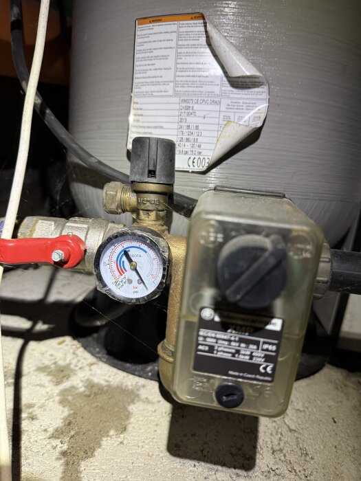 Manometer och anslutning på en Wellmate Pentair hydropress i en krypgrund, med mätaren som visar maxläge.