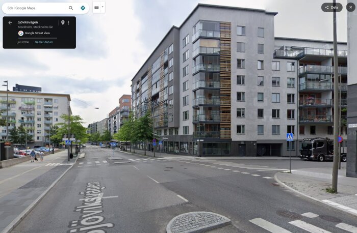 Nybyggda flerbostadshus längs Sjöviksvägen i Stockholm. Moderna, flervåningshus med balkonger och stora fönster. Växtplantering längs gatan.