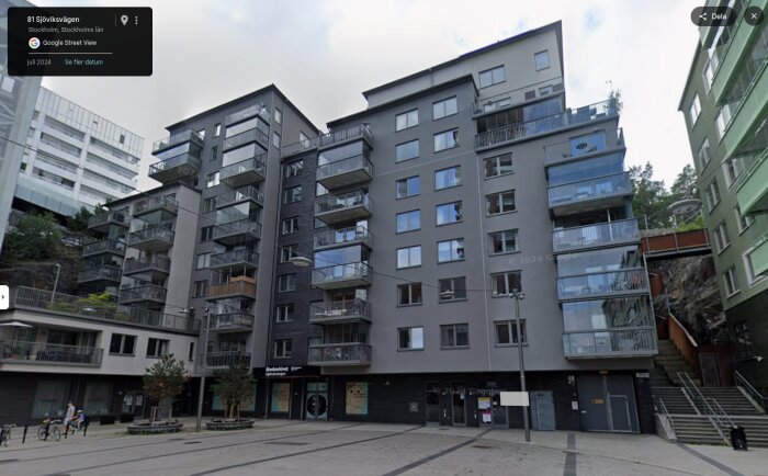 Flerfamiljshus i betong med flera våningar och balkonger i ett modernt bostadsområde på Sjöviksvägen i Stockholm.