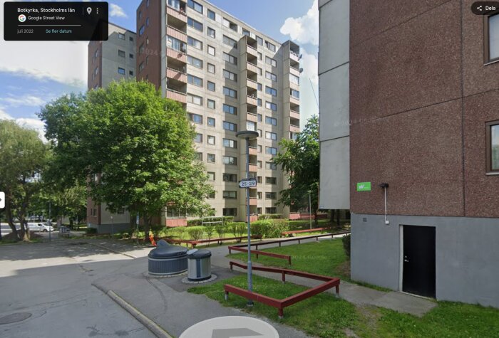 Flerbostadshus i vardagsmodern stil i förort till Stockholm, omgivna av grönska och trottoarer.