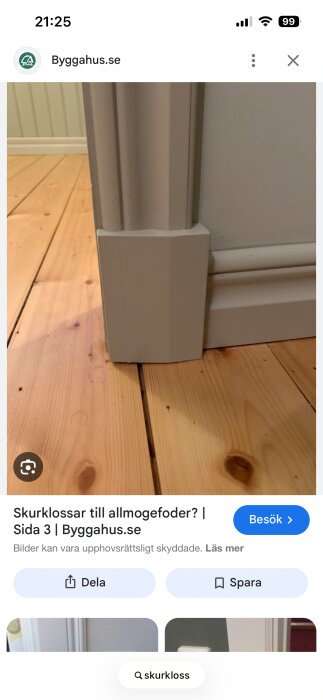Vit skurkloss vid grått dörrfoder och ljus trägolv.
