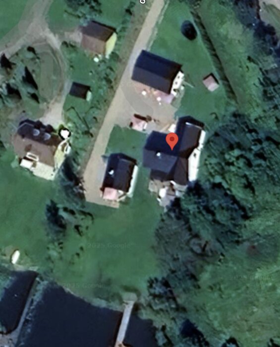Flygbild över ett bostadsområde med ett garage markerat. Garaget har stora fönster mot infarten för att smälta in visuellt.